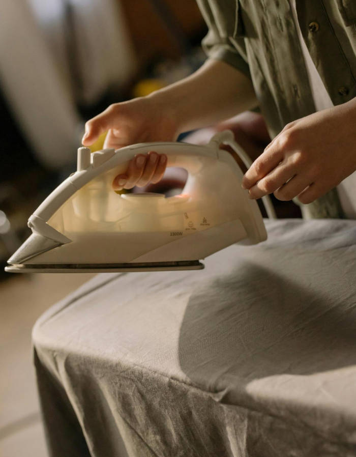 A portable ironing board being used in a hotel guest room.
